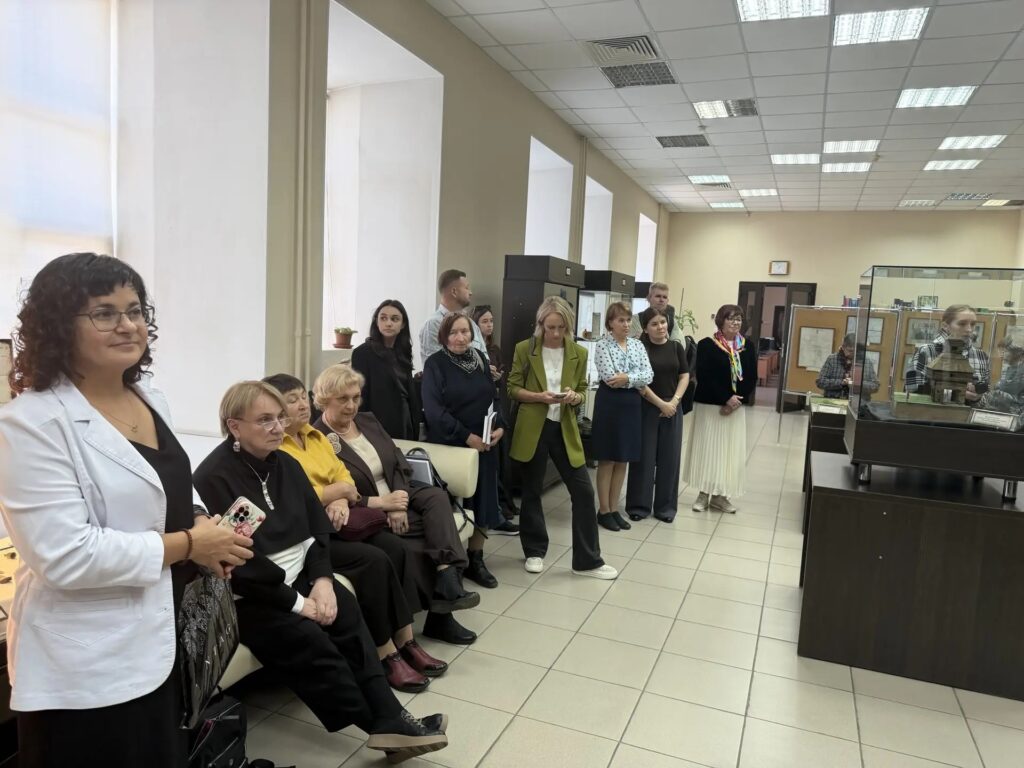 О.В. Петренко и участники симпозиума на фоне выставки